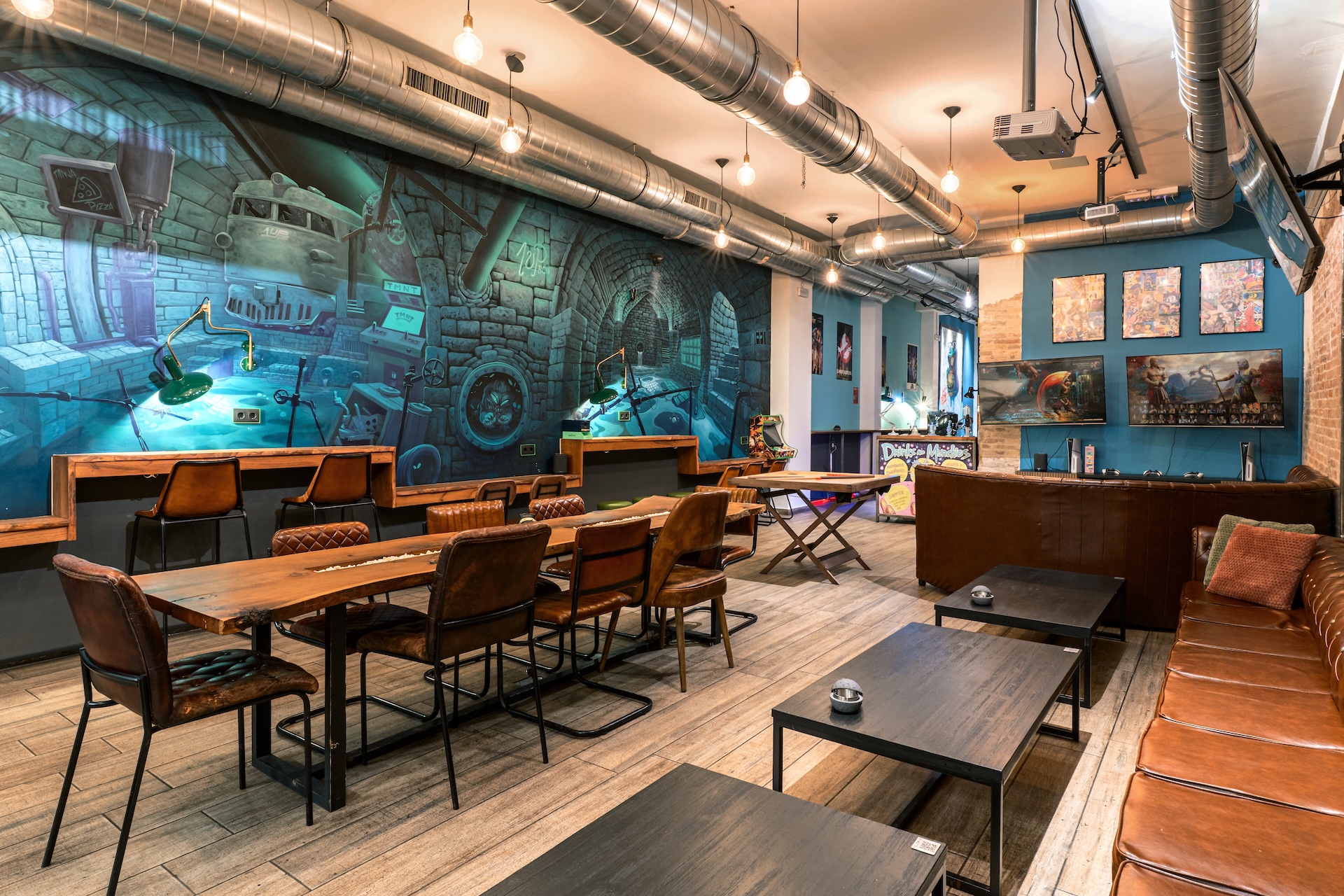 Sala principal de 1UP con mesa grande y mural estilo cómic