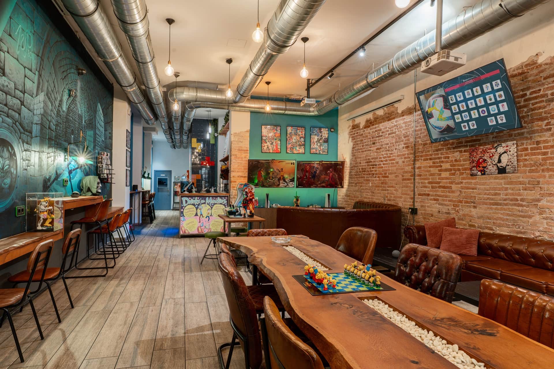 Muro artístico y zona de juegos de mesa en el club de cannabis 1UP en Barcelona